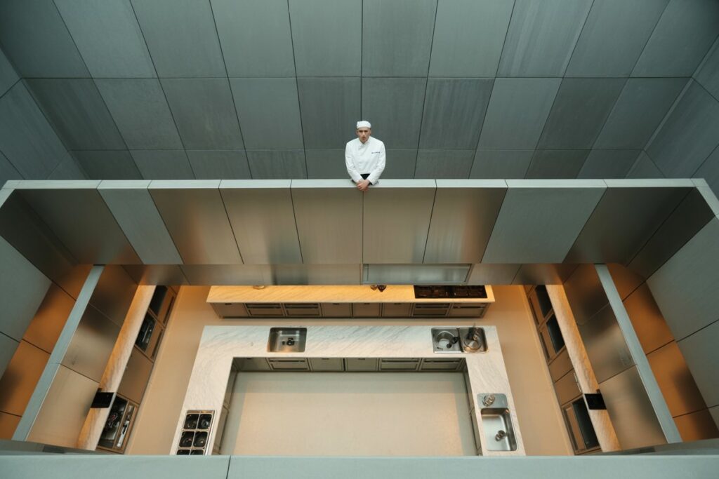 Chef overlooking a structured professional kitchen, symbolizing innovation starting at the top.