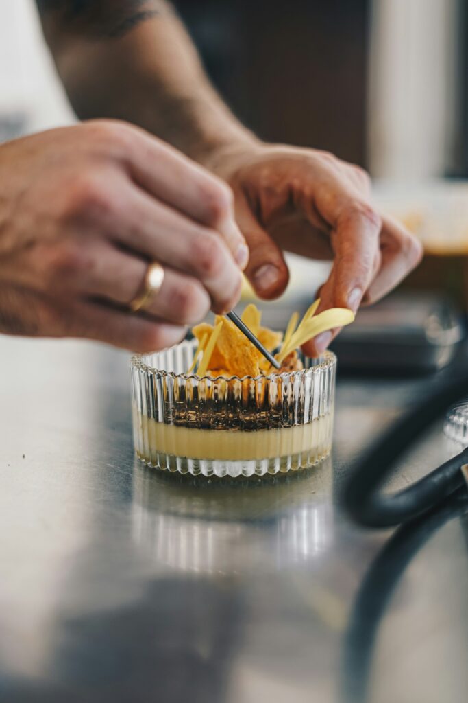 Chef plating a dish with precision, representing honest hospitality marketing and craftsmanship.