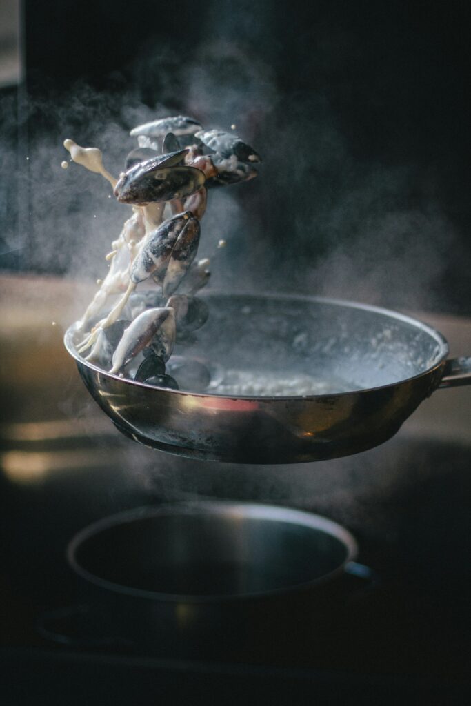 Black mussels tossed in a pan, focusing on heat control, timing, and culinary technique