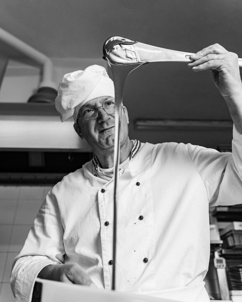 
chef plating dish with precision and minimalistic style